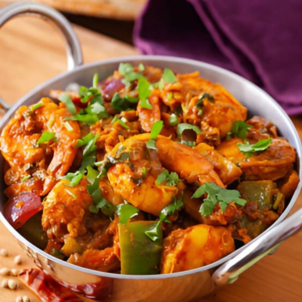 Mehfil Indian Restaurant's chicken curry with bell peppers and cilantro in a metal bowl.